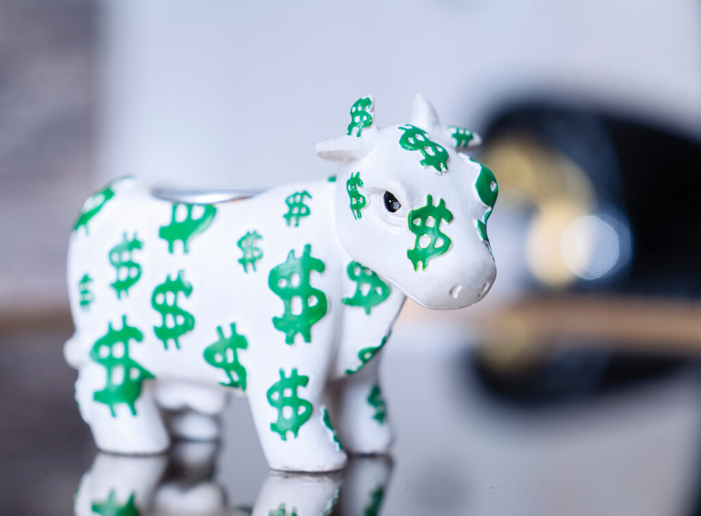 24 12 11 a white bull figurine with green dollar signs all over it mf dload gettyimages 1066588700 1087x800 480decc