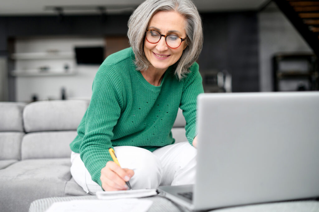 older adult in living room reviewing finances