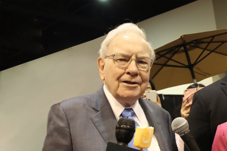 25 03 12 warren buffett speaking into microphones mf dload source motley fool buffett21 tmf