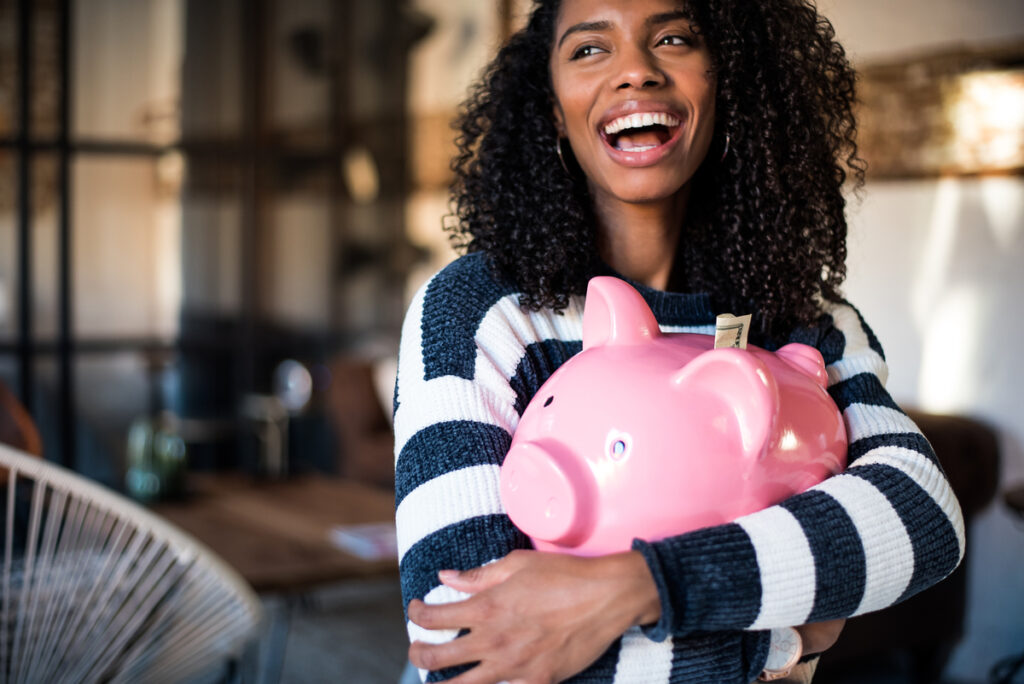 person holding a piggy bank smiling